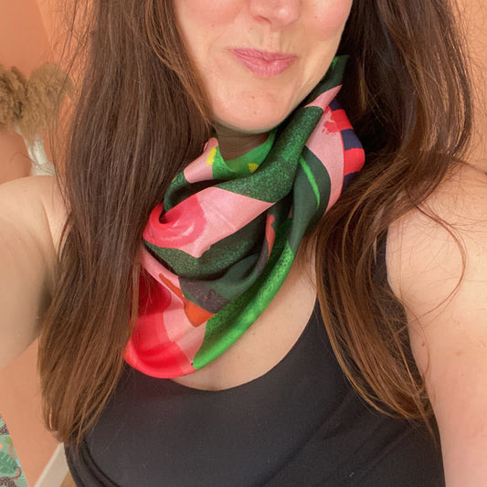 Woman wearing a colorful scarf with a neutral background